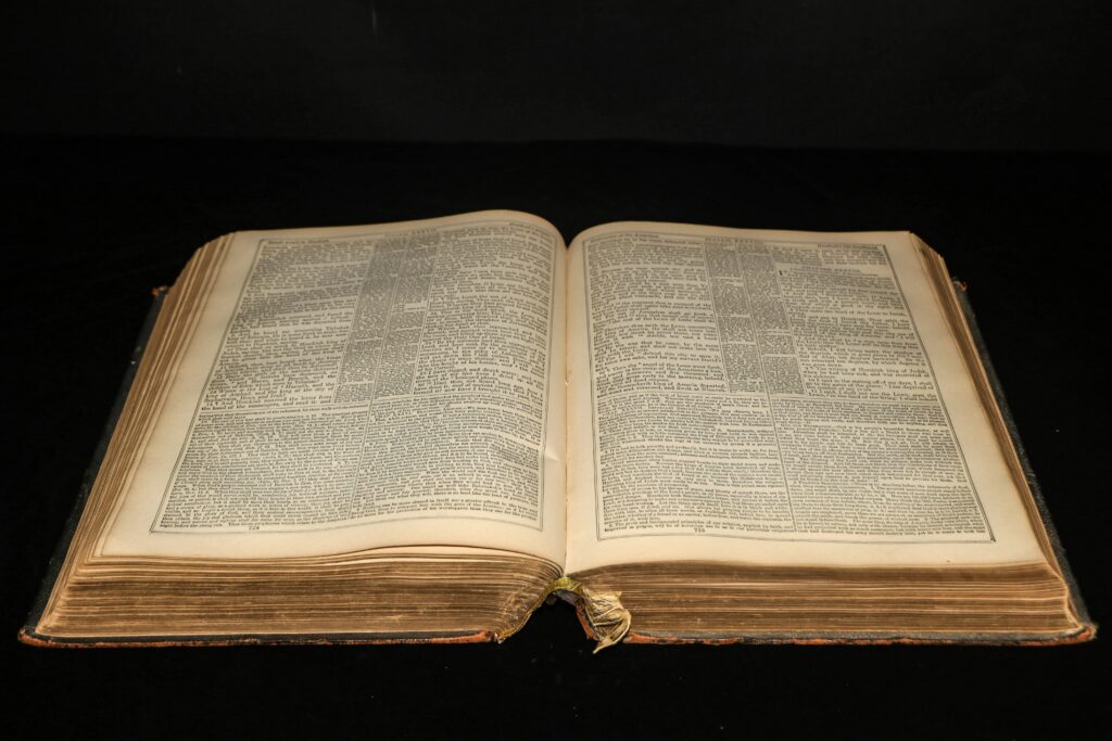 An image of an open book on a black background drawn from a stock image library. Credit to Danika Perkinson.